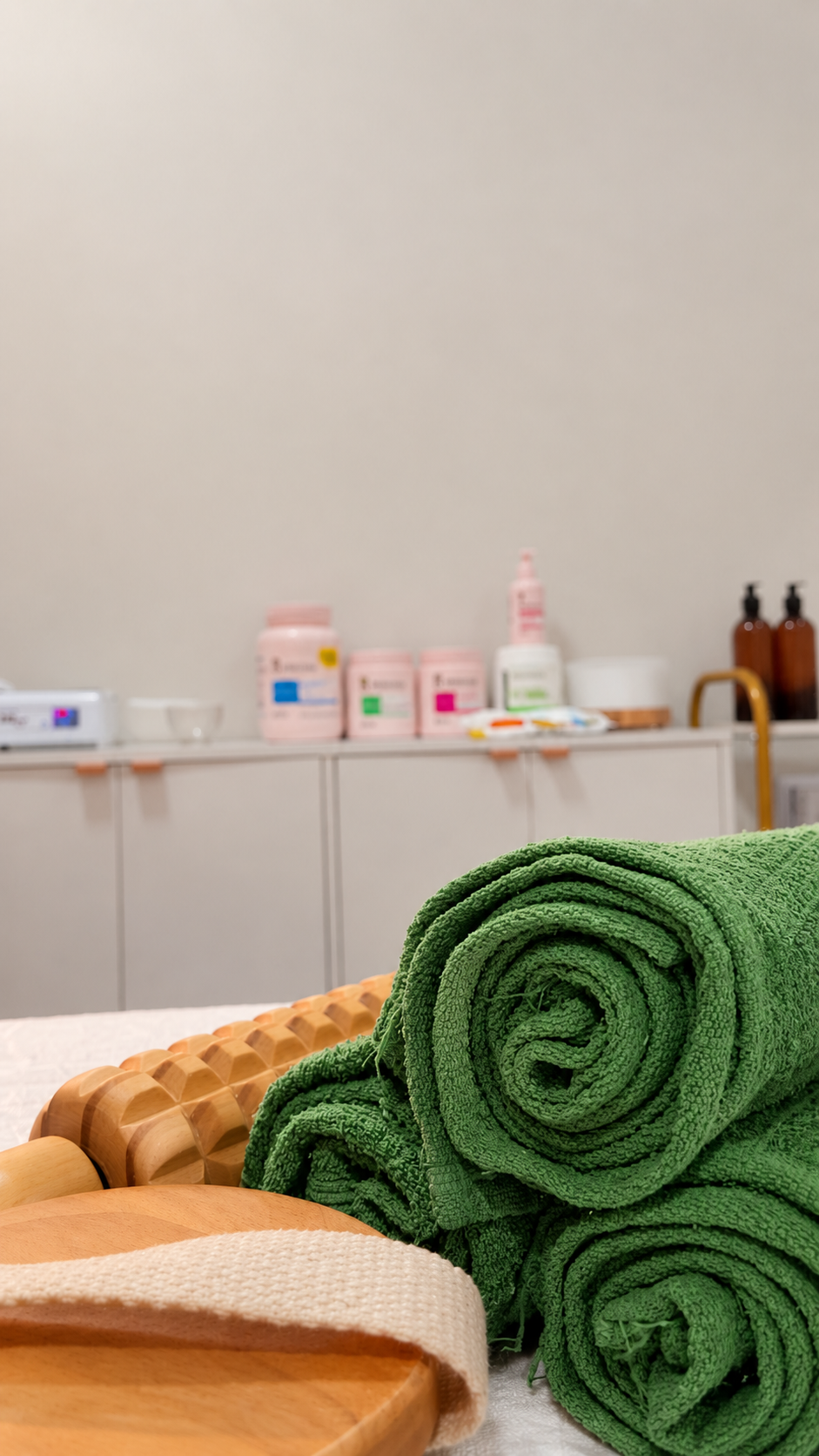 Detalhe de toalhas verdes e acessórios de massagem